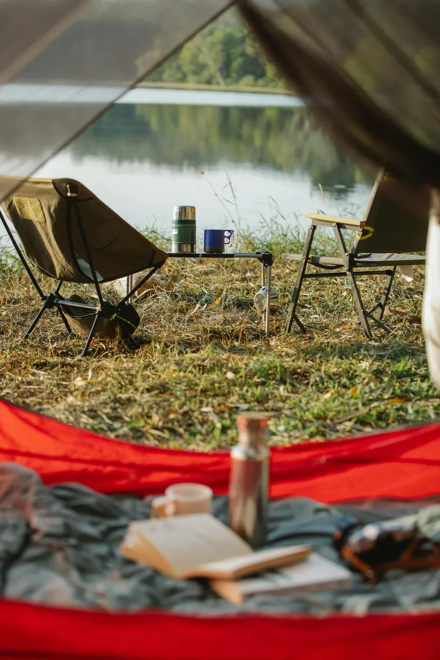 Camping setup by a lake with chairs and outdoor gear - perfect scenario for a portable power station like the Bluetti AC200L
