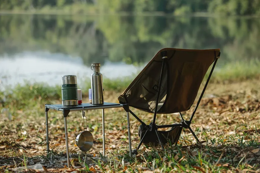 Camping setup by a lake with chair and table, perfect setting for portable power station use