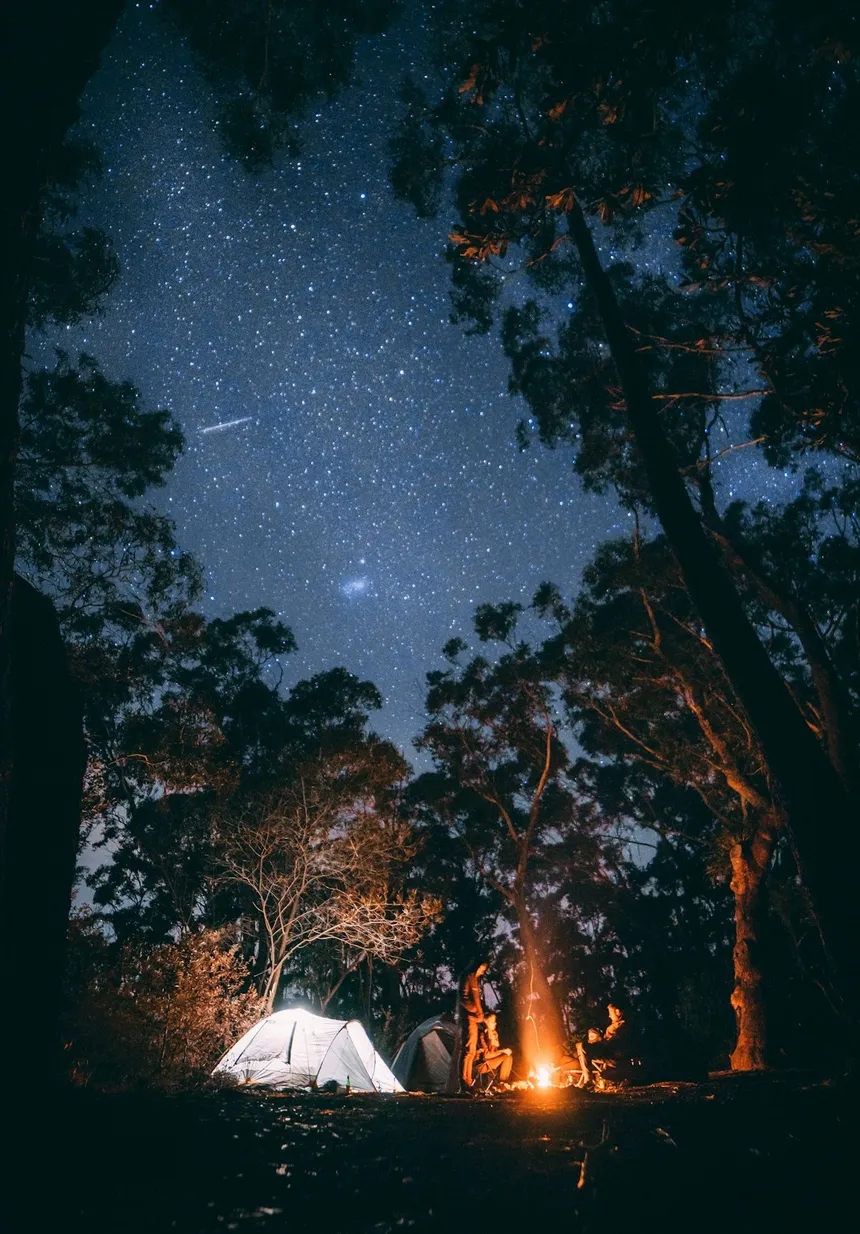 Nighttime camping scene with illuminated tent and starry sky - ideal for CPAP users needing overnight power